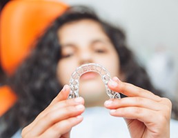 Teenager holding clear aligner