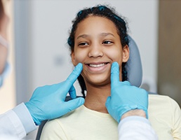 Dentist examining teen's teeth