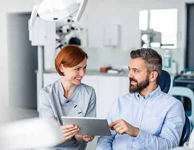 Smiling dentist reviewing treatment plan with patient